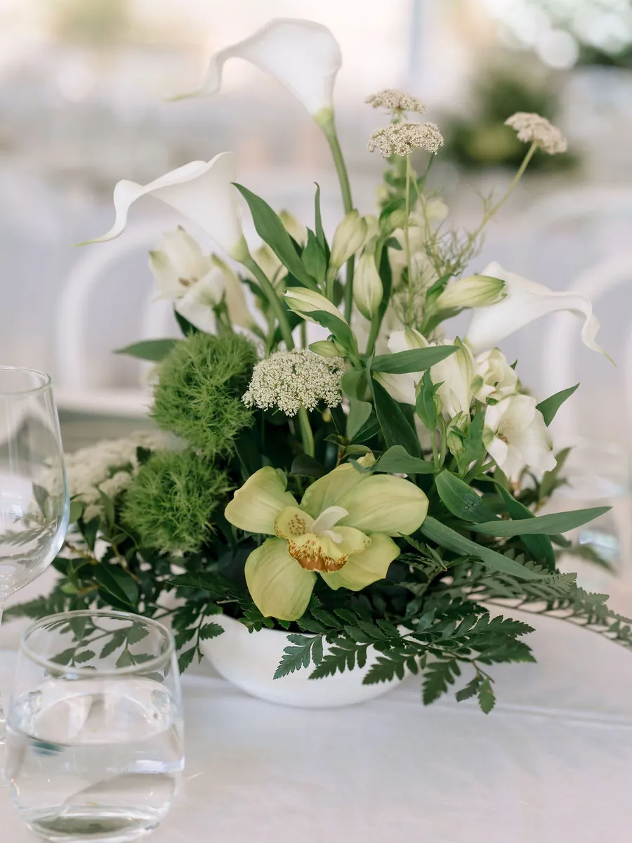 Green orchid and calla lily centrepiece on white linen