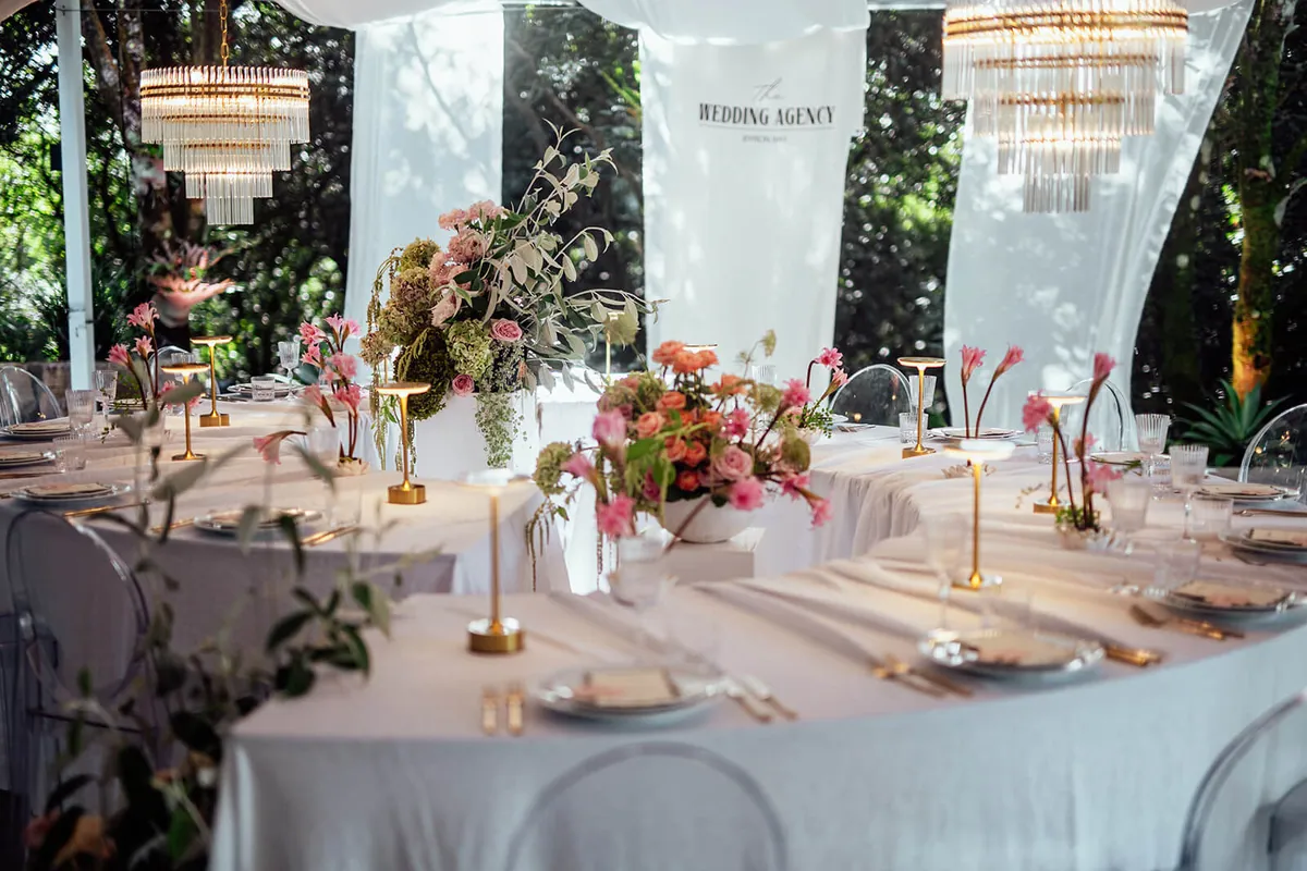 Chandeliers and floral centrepieces across round reception tables